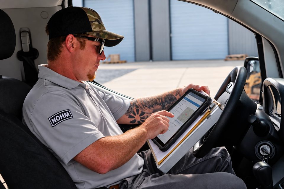 A NOHM pro in his van reviewing the home&rsquo;s equipment and past repairs on his tablet before heading to the job